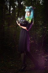 Naklejka premium Beautiful woman with color hair and horns holds black bouquet