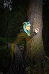 Beautiful woman with color hair and horns holds black bouquet