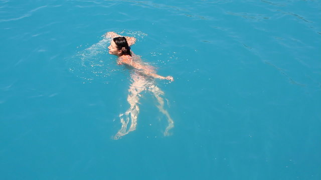 Young woman swimming in the blue sea