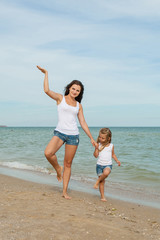 Mother and her daughter  having fun on the beach