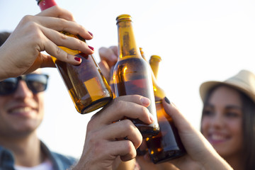 Portrait of group of friends toasting with bottles of beer.