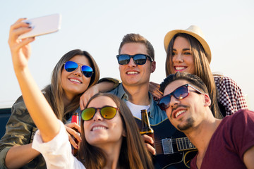 Group of friends taking a selfie with smartphone.