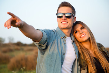 Portrait of happy young couple in field.