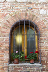 Fototapeta na wymiar Window with iron bars on a wall from Tuscany
