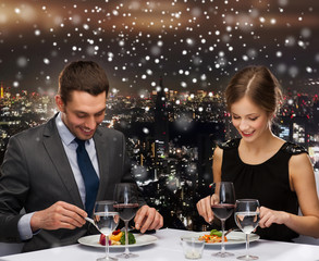 smiling couple eating main course at restaurant
