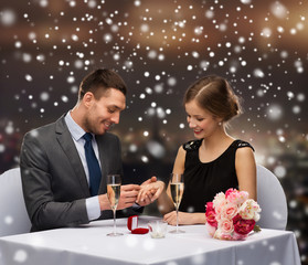 smiling couple with red gift box at restaurant