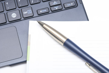 Notepad and pen on keyboard
