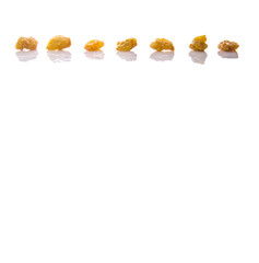 Golden colored dried raisin over white background