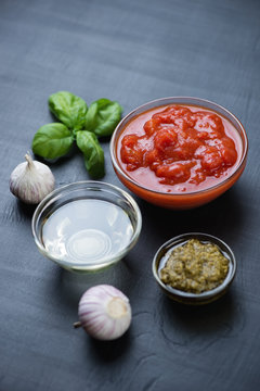 Chopped tomatoes, basil pesto, olive oil and garlic, studio shot