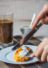 eat curd cheese pancakes with sour cream for breakfast, hands