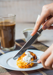 eat curd cheese pancakes with sour cream for breakfast, hands