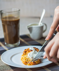 eat curd cheese pancakes with sour cream for breakfast, hands