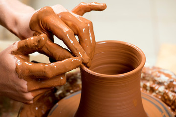 hands of a potter, creating an earthen jar