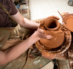 hands of a potter, creating an earthen jar