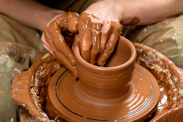 hands of a potter, creating an earthen jar