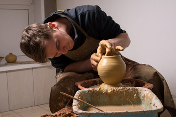 hands of a potter, creating an earthen jar