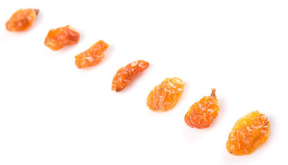Dried orange colored raisin over white background