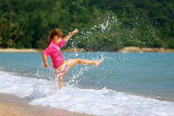 Happy little girl enjoying holiday beach vacation.
