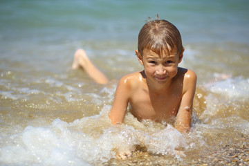 Fototapeta na wymiar kid in the foam of waves
