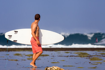 Surfer with surfboard on a coastline