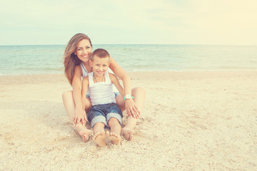 Fototapeta premium Mother and her son having fun on the beach