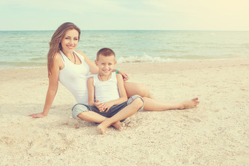 Fototapeta premium Mother and her son having fun on the beach