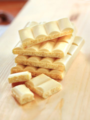 Bars of white porous chocolate on wooden background
