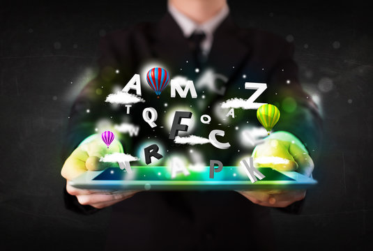 Young person showing tablet with abstract letters and sky
