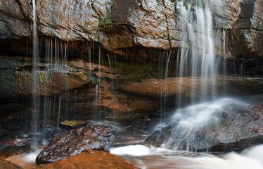 Mountain river waterfall, wet stones and silky water