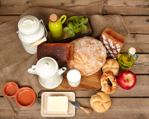 Fresh bread and butter and milk on wooden background