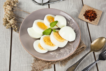 Boiled eggs with mint leaf and white wooden table