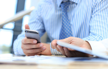Smartphone handheld in closeup, colleagues working in background