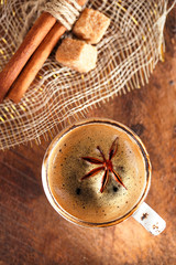 A cup of spiced coffee with anis star and cinamon sticks and sug
