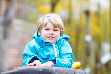 Little kid boy having fun on autumn playground