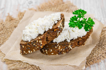Two sandwich with curd cheese and parsley.