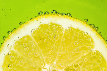Fresh lemon in soda water covered with bubbles