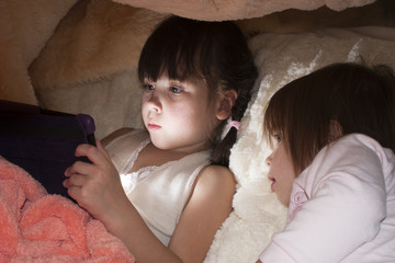 Дети вместо сна играют в планшет под одеялом