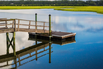 Fototapeta na wymiar Boat Dock reflecting in inlet marsh water