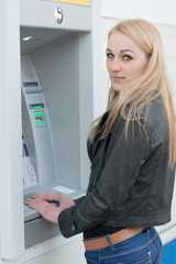 Fototapeta na wymiar Woman using Bank ATM machine