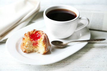 Cup of coffee with tasty cookie on color wooden background