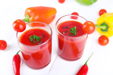 Tomato juice in glasses and fresh vegetables