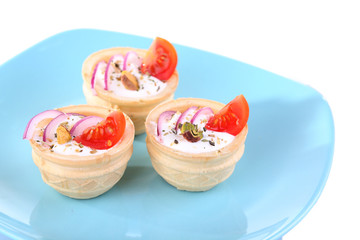 Tartlets with greens and vegetables with sauce on plate