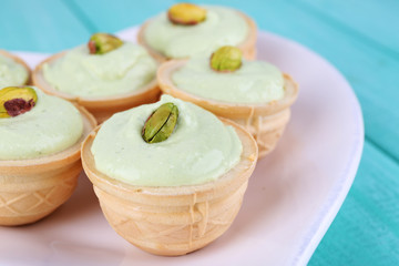 Tartlets with greens and sauce on plate close-up