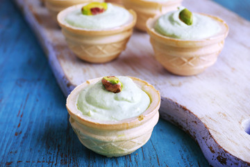 Tartlets with greens and sauce on tray on table