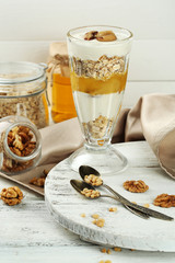 Tasty dessert with oat flakes and honey, on table