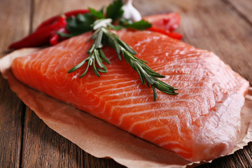 Fresh salmon with spices on wooden table