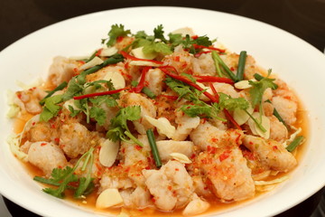 Spicy salad with  shrimp, fish and vegetables on white dish.