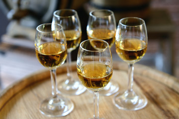Glasses of wine in cellar with old barrels