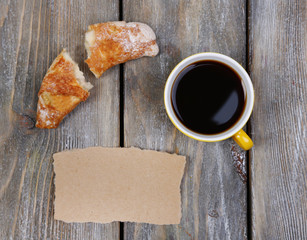 Composition of coffee, fresh croissant and paper card