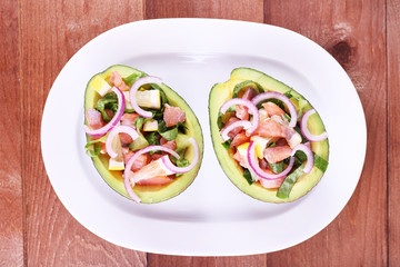 Tasty salad in avocado on plate table close-up